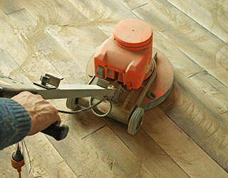 grinder sanding wood flooring surface