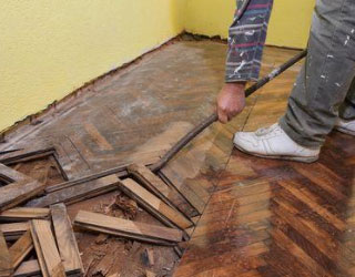 man repairing hardwood floor