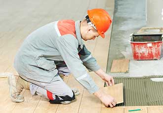 Worker installing floor tile