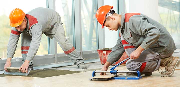 Two flooring contractor installing floor tile