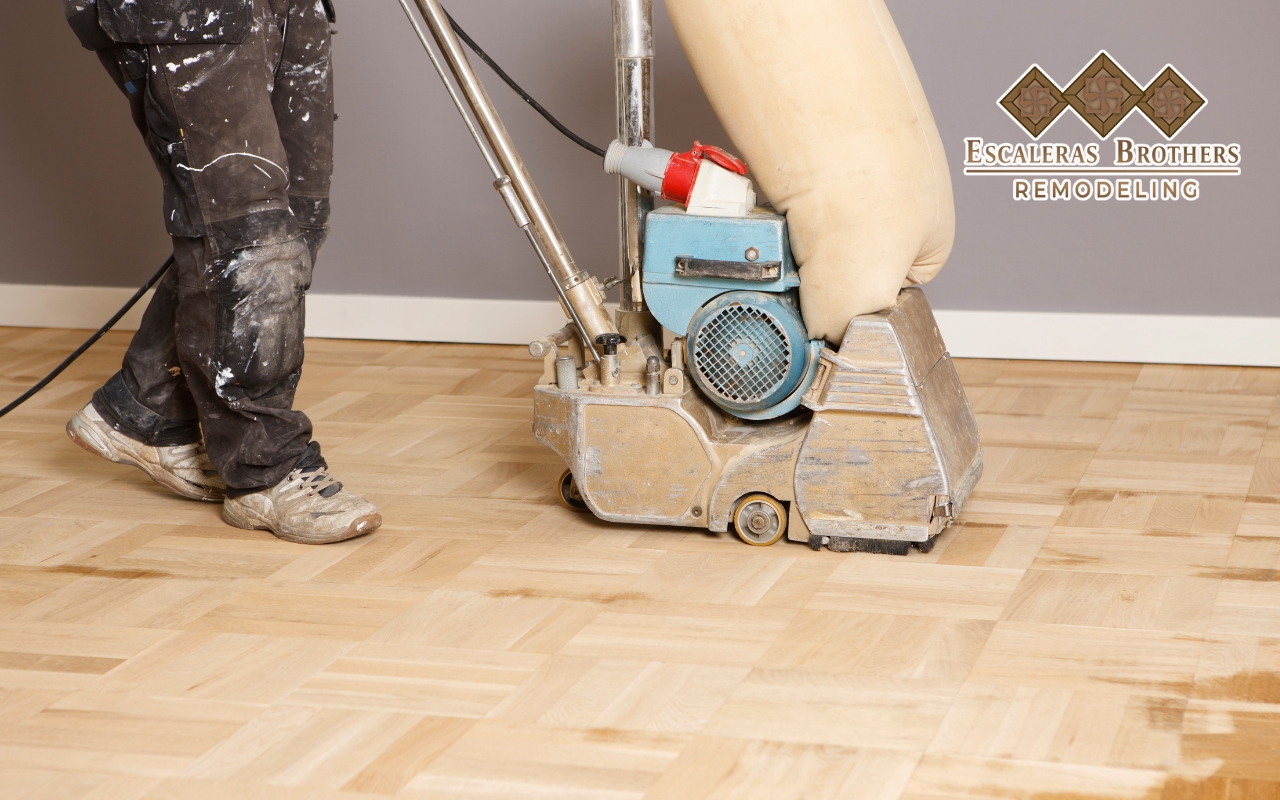 Sanding hardwood floors to achieve a smooth and even surface for refinishing.